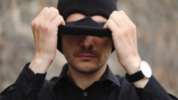 英俊的罪犯与手表戴上黑色防盗面具 并显示直接对预期受害者慢动作特写 — 图库视频影像