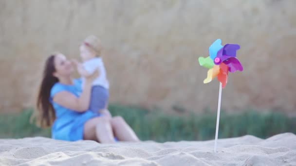 Wazige Langharige Dame Blauwe Jurk Speelt Met Jongen Peuter Pinwheel — Stockvideo