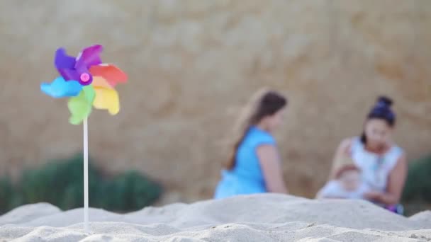 Расплывчатые Женские Силуэты Играют Малышом Песчаном Пляже Вертушкой Вращающейся Ветру — стоковое видео