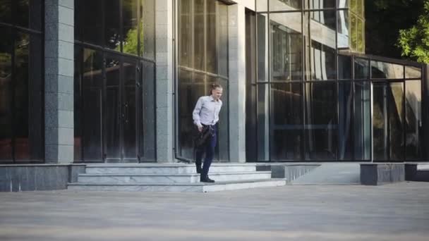 Flexibele Jonge Man Met Handtas Dansen Buurt Van Kantoorgebouw Ingang — Stockvideo