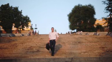 çanta ile şık adam mavi gökyüzü yavaş hareket karşı ünlü taş adımlar dans başarılı anlaşma kutluyor