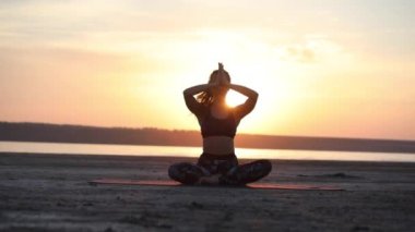 ince kadın uygulamaları yoga resimli turuncu günbatımı arka karşı deniz plajında ruh sağlığı nı iyileştirmek pozlar