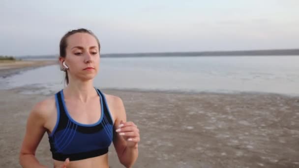 Young Woman Slim Body Long Dark Ponytail Airpods Enjoys Running — Stock Video