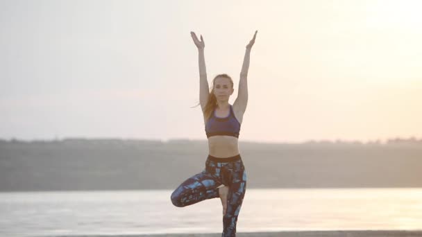 Медитирующая Молодая Женщина Практикует Позицию Йоги Дереве Держа Руки Над — стоковое видео