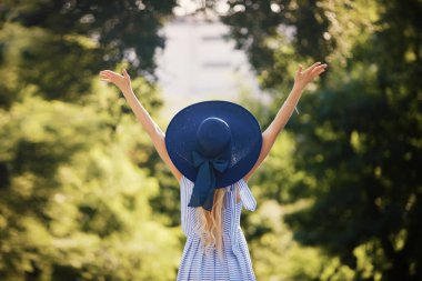 Güneşli bir gün tatil üzerinde şık mavi güneş şapka ile genç kadının moda portresi. Arkadan görünüm