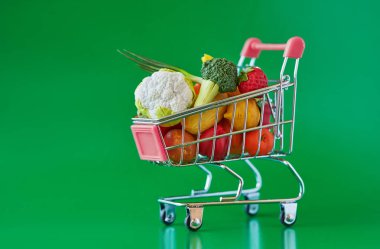 Taze sebze ve meyveler ile bakkal alışveriş sepeti. Yeşil üzerinde izole. Ücretsiz GMO