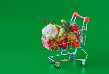 Taze sebze ve meyveler ile bakkal alışveriş sepeti. Yeşil arka planda izole edilmiştir. Ücretsiz GMO. Suni plastik ürünler