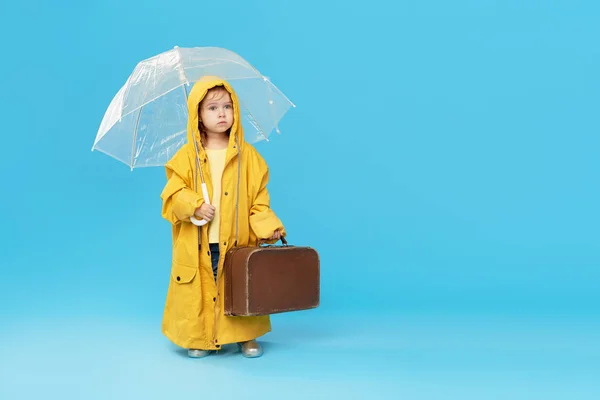 스튜디오 배경에 우산을 어린이 소녀는 노란색 비옷에 고무장화를 빈티지 가방을 — 스톡 사진