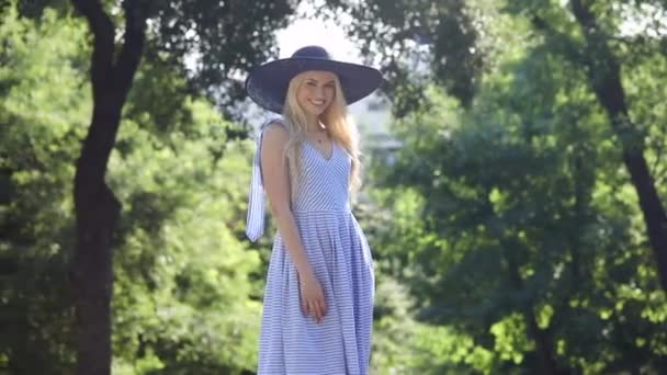 Excitante dama en azul blanco vestido a rayas y sombrero negro — Vídeo de stock