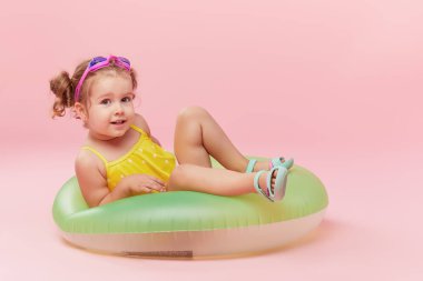 Pembe arka planda izole eğlenceli Neon şişme kauçuk daire ile mutlu küçük kız portresi