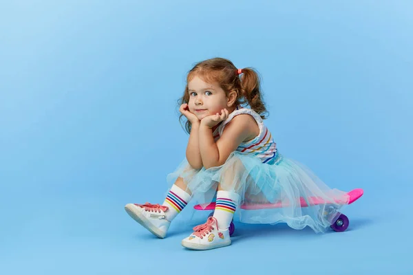 Menina Pequena Fresco Roupas Brilhantes Detém Skate Olhando Para Câmera — Fotografia de Stock