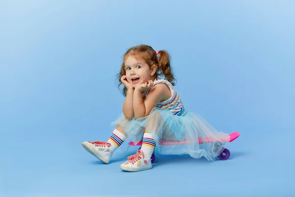 Cool Pequeña Niña Ropa Brillante Sostiene Monopatín Mirando Cámara Aislada —  Fotos de Stock