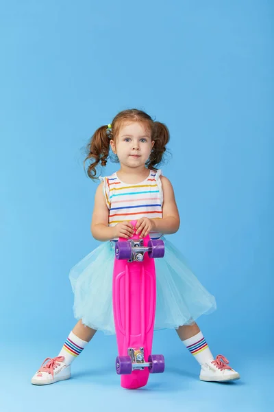 Menina Pequena Fresco Roupas Brilhantes Detém Skate Olhando Para Câmera — Fotografia de Stock