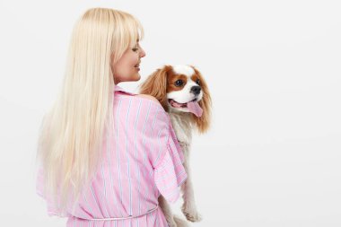 Spaniel köpek kucaklayan gülümseyen genç sarışın kadın Closeup portre. sahibi ve evcil hayvan ilişkileri kavramı. Veteriner. Beyaz arka planda yalıtılmış ön görünüm.