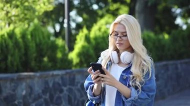 güzel kız akıllı telefon bakarak dolaşır şok alır