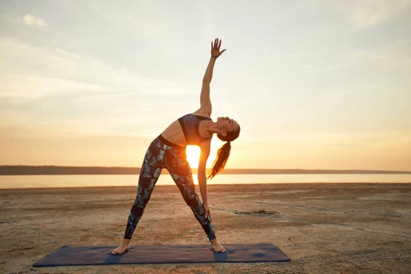 Yoga ve fitness. Genç kadın plajda doğada sabah meditasyon pratik