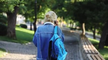 parkta akıllı telefon ve kulaklık ile denim ceket şık öğrenci kız
