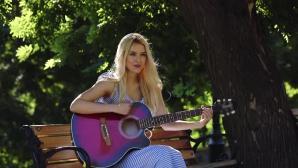 时尚学生女孩在夏装打吉他在公园 — 图库视频影像