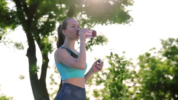 Bilder Fit Ung Kvinna Dricksvatten Medan Tränar Utomhus — Stockvideo