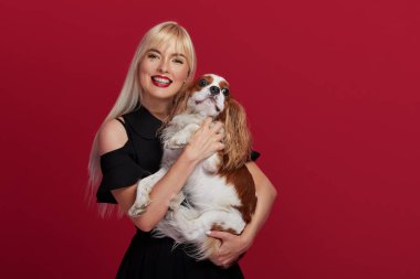 Parti zamanı! Sevimli köpek ile siyah elbiseli genç kutlayan kadın portresi