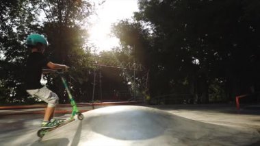 okul çocuğu gri piramit üzerinde scooter sürmek ve atlar