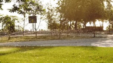 çocuk siluet su jeti arkasında park boyunca scooter sürmek