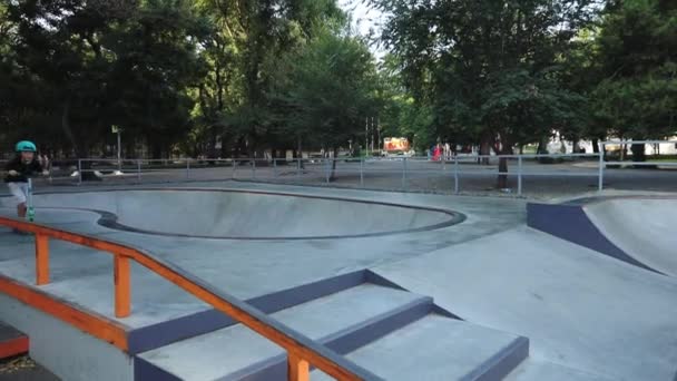 Школярка стрибає зі сходів і їде вздовж скейт-парку — стокове відео