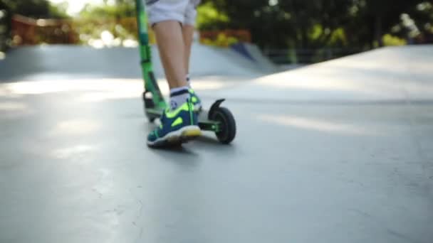 Kind fährt Roller entlang Skatepark Pool langsam Nahaufnahme — Stockvideo