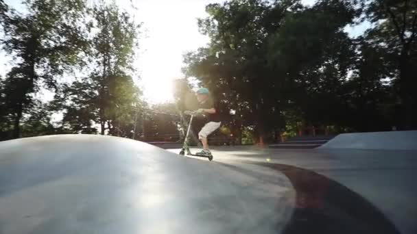 Patineur promenades scooter sur pyramide grise et saute extrêmement lent — Video