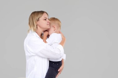 Genç anne ağlayan çocuğunu kucağına tutuyordu. Oğlu hasta ve kötü hissediyor, kadın üzgün bebek için üzgün