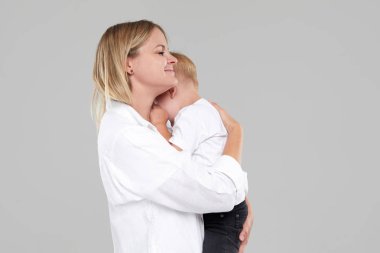 Genç anne ağlayan çocuğunu kucağına tutuyordu. Oğlu hasta ve kötü hissediyor, kadın üzgün bebek için üzgün