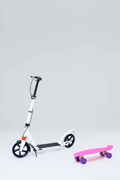 Electric kick modern scooter and skateboard isolated on grey background. Eco alternative transport concept.