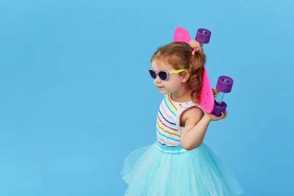 Cool Kis Kisgyermek Lány Fényes Ruhákat Napszemüveg Kezében Egy Gördeszka — Stock Fotó