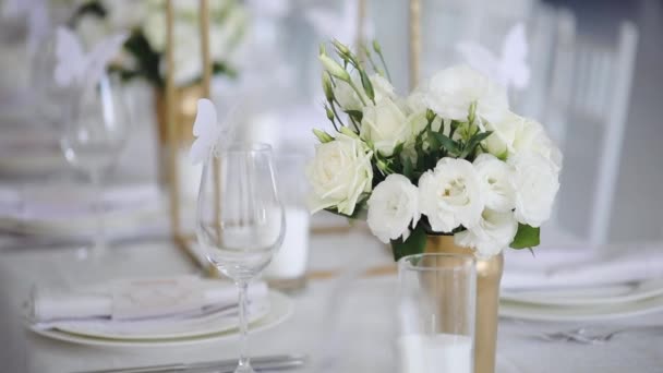 Прекрасное оформление стола с цветочными букетами и тарелками — стоковое видео