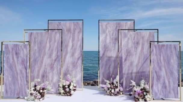 Site arc élégant décoré avec des fleurs contre la mer bleue — Video