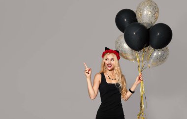 beyaz arka plan üzerinde parti üzerinde balonlar ile siyah cadı cadılar bayramı kostümü iki mutlu genç kadının portresi. Cadılar Bayramı kavramı . komik yüz