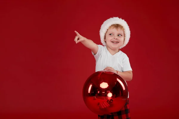 Little Kid Boy Santa Claus Kapelusz Trzyma Wielką Piłkę Czerwonym — Zdjęcie stockowe