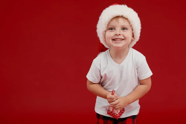 크리스마스와 홀리데이 귀여운 소년은 실내크리스마스 트리를 장식하고 있습니다 빨간색 배경에 — 스톡 사진