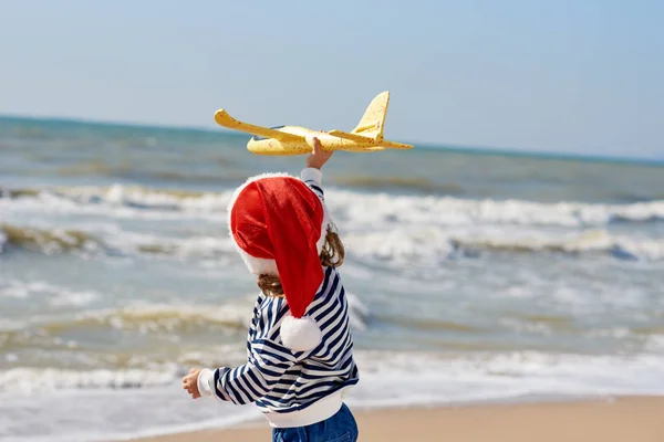 Dziewczynka Santa Kapelusz Gry Samolotu Zabawka Słonecznej Tropikalnej Plaży Boże — Zdjęcie stockowe