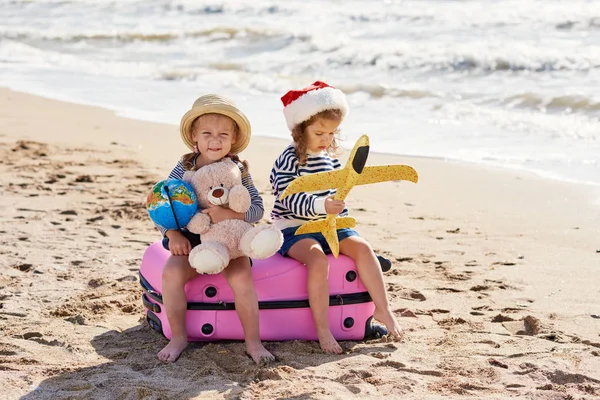 Szczęśliwe Małe Dzieci Santa Hat Walizką Kuli Ziemskiej Piasku Tropikalnej — Zdjęcie stockowe