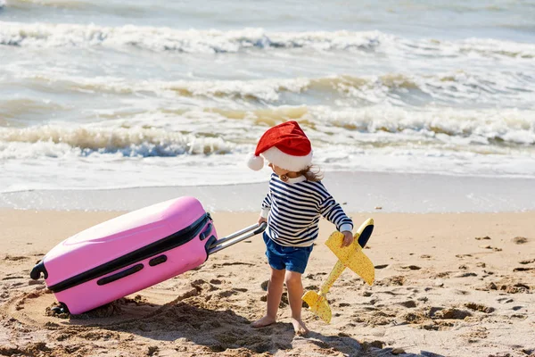 Little Child Santa Hat Rolls Suitcase Tropical Beach Winter Holidays — Stock Photo, Image