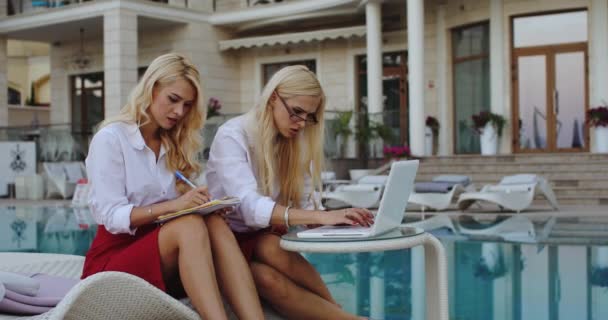 Близнецы деловые женщины шокированы, глядя на дисплей ноутбука — стоковое видео