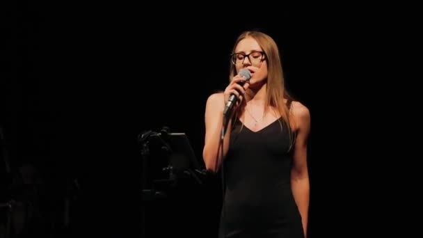 Bonita senhora vestindo elegante vestido preto executa no palco — Vídeo de Stock