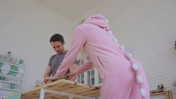 Señora vistiendo bastante rosa dinosaurio kigurumi cocina ensalada — Vídeos de Stock
