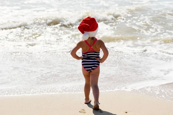 Little Girl Child Swimsuit Santa Hat Walks Tropical Beach Ocean — Stock Photo, Image