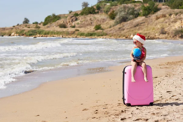 Happy Little Girl Dziecko Santa Kapelusz Walizką Kuli Ziemskiej Tropikalnej — Zdjęcie stockowe