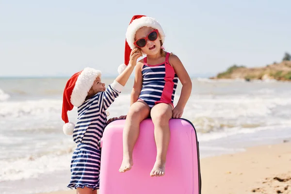 Szczęśliwe Małe Dzieci Dziewczynki Kapeluszach Mikołaja Walizką Globusem Tropikalnej Plaży — Zdjęcie stockowe