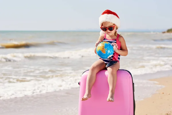 Happy Little Girl Dziecko Santa Kapelusz Walizką Kuli Ziemskiej Tropikalnej — Zdjęcie stockowe