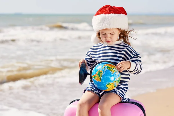 Happy Little Girl Dziecko Santa Kapelusz Walizką Kuli Ziemskiej Tropikalnej — Zdjęcie stockowe