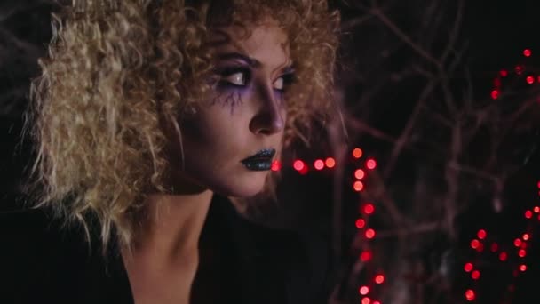 Женщина позирует глядя в сторону против Хэллоуина украшения — стоковое видео